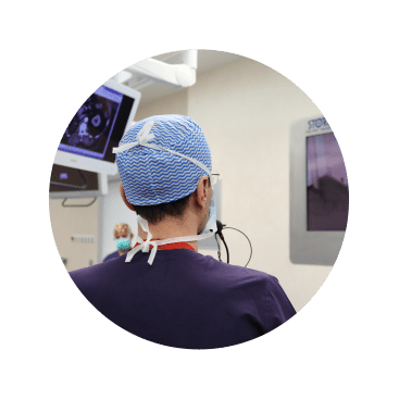 Imagem de cirurgião de costas a analisar um ecrã.